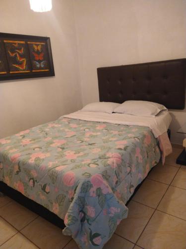 伊察LUGAR DE DESCANSO的一间卧室配有一张带花卉棉被的床