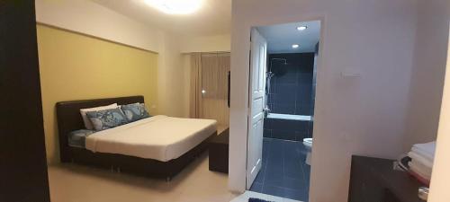 怡保K. Riverfront apartment的一间卧室配有一张床,浴室设有淋浴。