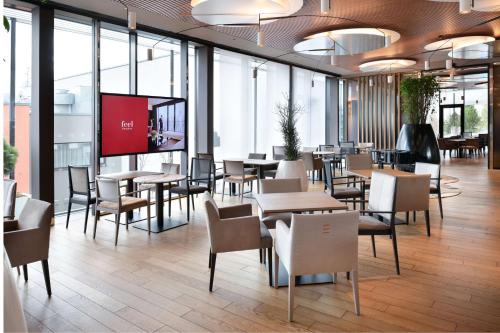 奥洛穆茨奥洛穆茨议会NH系列乔利酒店的餐厅设有桌椅和投影屏幕