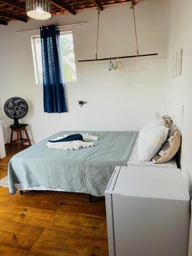 阿廷斯Quartinho Branco的一间卧室配有一张床和一台冰箱
