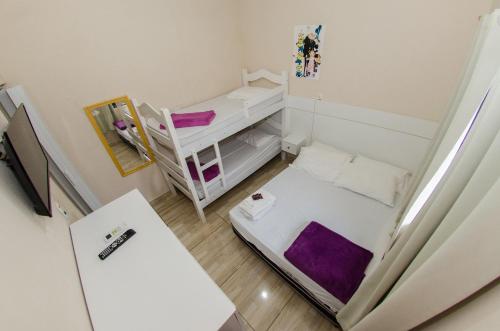 佩尼亚Pousada Esperança的小房间设有双层床和书桌