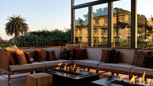 卡梅尔La Playa Hotel的客厅配有沙发,庭院设有壁炉