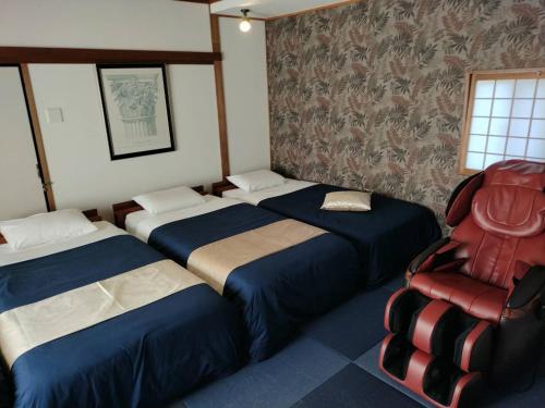 南淡路市奥提伽别墅 的一间设有三张床和椅子的房间