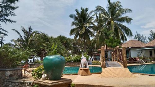 Ban Ai DaoLanta Villa Resort的度假村的游泳池,带大型绿地