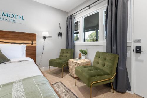 三河城The Belle Sequoia Motel RM9的一间卧室配有一张床和两张绿色椅子