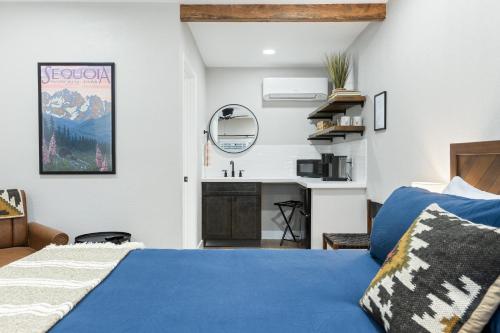 三河城The Charlotte Sequoia Motel R2的一间卧室配有蓝色的床和水槽