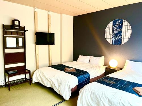 岸和田市民泊Murakami International的一间酒店客房,设有两张床和电视