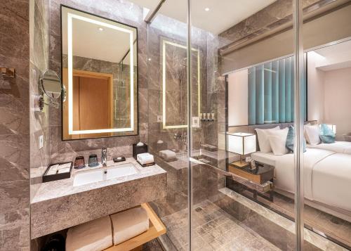 成都秦皇永安精品酒店的带淋浴和盥洗盆的浴室以及1张床。