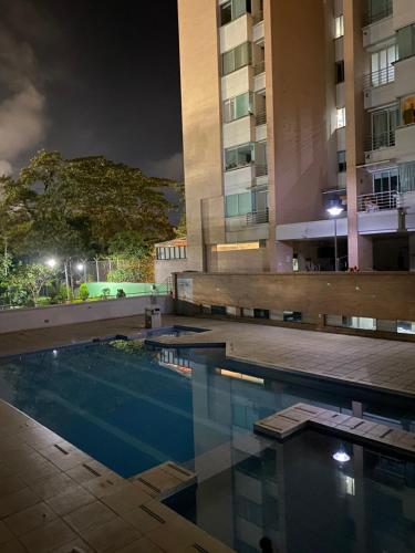 伊瓦格Apartamento completo的一座游泳池,在晚上在建筑物前