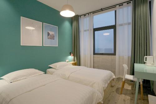 长沙天鹅之旅国际青年旅舍(长沙五一广场IFS国金中心店)的一间卧室设有两张床、一张桌子和一个窗口。