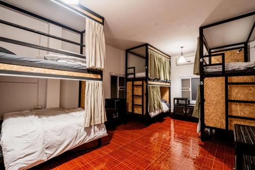巴色ANOU HOSTEL的一间卧室设有两张双层床,铺有红色瓷砖地板。