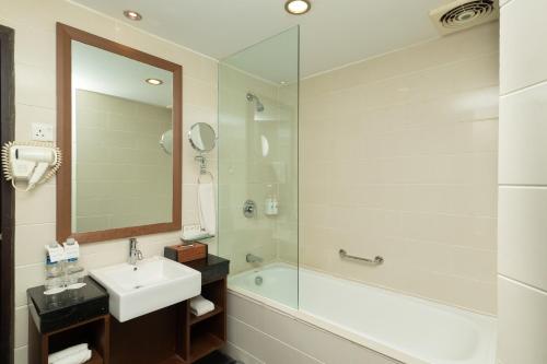 名古屋Swiss-Belinn Baloi Batam的一间带水槽、淋浴和镜子的浴室