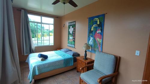 博卡奇卡Boca Chica BnB at Gone Fishing Panama Resort的卧室配有床、椅子和窗户。