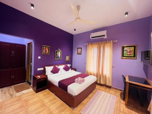 蒙纳Munnar Blue Mist的一间卧室设有紫色的墙壁和一张带粉红色枕头的床