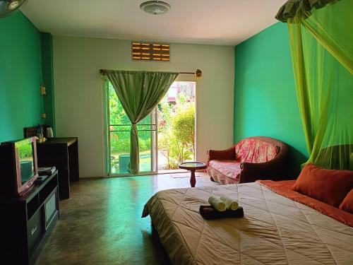 清莱六个自然度假酒店的一间卧室配有一张床、一台电视和一把椅子