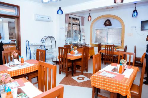 姆万扎Port Park Hotel的餐厅设有木桌、椅子和窗户