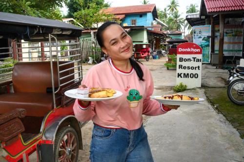 Ban KhonBontai Resort, Don Khon的女人拿着两盘食物