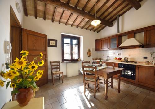 阿西西莫贝拉洛萨农家乐的一间带桌椅的厨房和一间用餐室