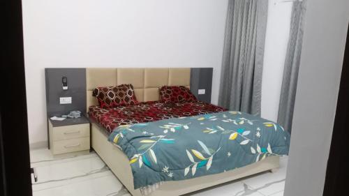 勒克瑙Sindhu Villa的一间小卧室,配有一张带蓝色棉被的床