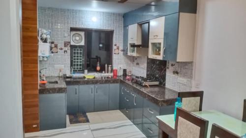勒克瑙Sindhu Villa的厨房配有蓝色橱柜和瓷砖墙