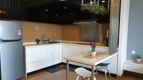 蕉赖Eshue Designer Suites @ Simfoni Towers的厨房配有桌子和冰箱