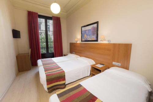 巴塞罗那Ciudad Condal Hostal - Paseo de Gracia的酒店客房设有两张床和窗户。