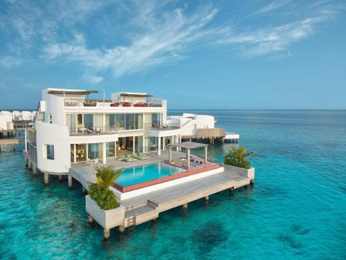 北马累环礁Jumeirah Olhahali Island Maldives的海洋中水面上的房屋