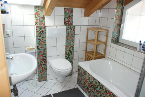 施瓦茨Haus am Lahnbach的浴室配有卫生间、浴缸和水槽。