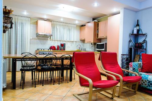 普雷代亚尔Holiday Vila Predeal的厨房配有餐桌和红色椅子