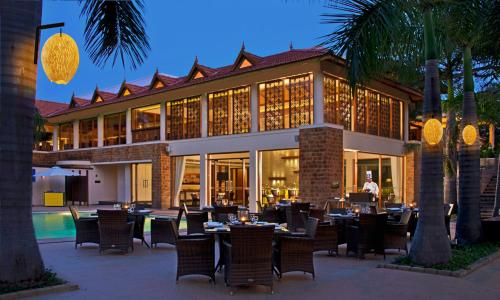 海得拉巴The Golkonda Resort and Spa的大楼前设有桌椅的餐厅