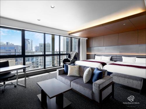 神户Daiwa Roynet Hotel KOBE-SANNOMIYA PREMIER的酒店客房,设有两张床和一张沙发