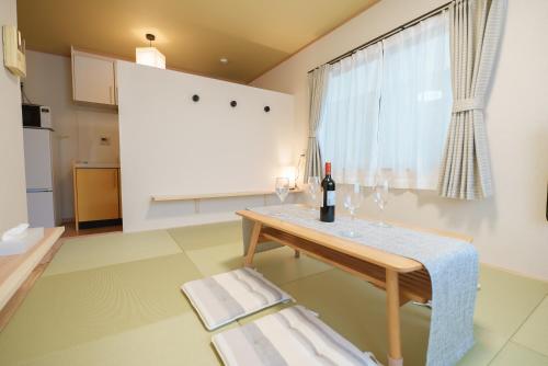 东京匯家•平和島ビル的客厅配有桌子和一瓶葡萄酒