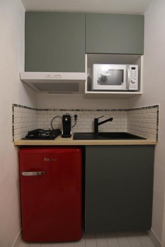 索沃泰尔joli studio indépendant avec kitchenette的厨房配有红色冰箱和微波炉