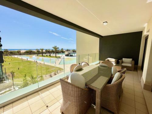 卡内拉岛OCEAN HOMES Apartamentos exclusivos en Isla Canela by AC REAL的一间带桌椅和大窗户的用餐室