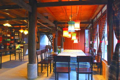 萨帕Traditional Wooden house & trekking adventure的用餐室配有桌椅和灯