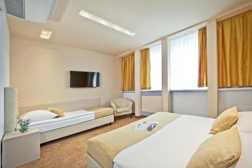 萨格勒布中心酒店的一间酒店客房,设有两张床和电视