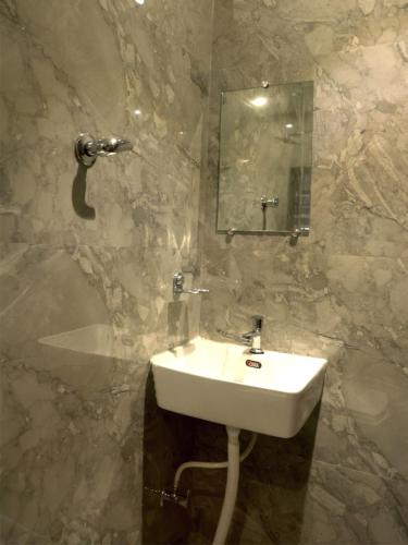 UlhāsnagarHotel Majestic的一间带水槽和镜子的浴室