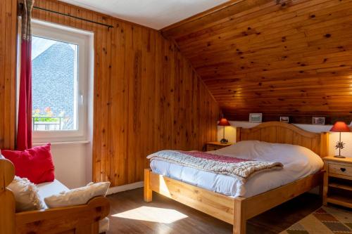 Saint-Jean-Saint-NicolasLES PRIMEVERES的卧室设有木墙、一张床和窗户