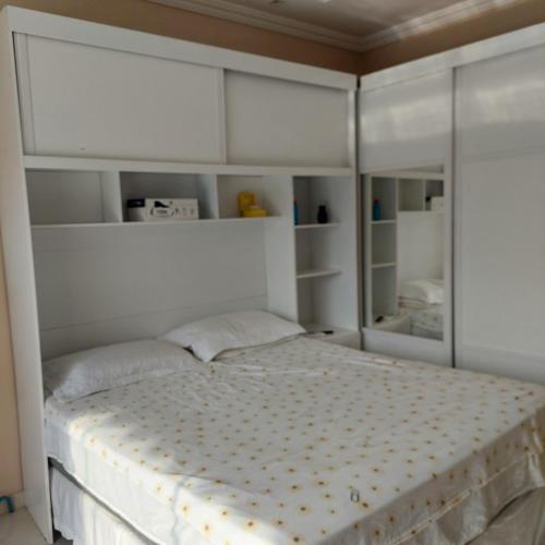 马瑙斯DUPLEX ALTO PADRÃO NO COND. OURO NEGRO - COROADO的一间卧室配有一张带白色橱柜的大床