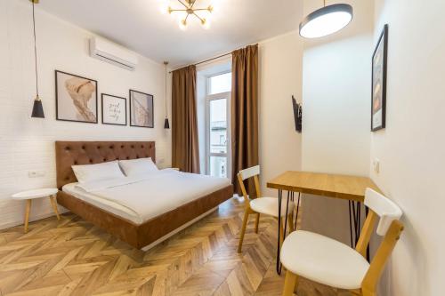 基辅Idea Design Apart-Hotel Chykalenka的卧室配有一张床和一张桌子及椅子