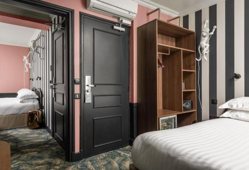 巴黎Hotel Archetype Etoile的一间卧室设有两张床和一扇黑色的门