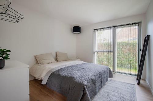 哥本哈根Spacious family house的白色的卧室设有床和大窗户