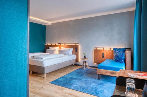 慕尼黑Unsöld's Factory Hotel的一间卧室设有一张床和蓝色的墙壁