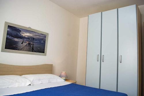 佩斯科勒海滨Appartamenti in Via Schipa Pescoluse的一间卧室配有一张床和一个大衣柜