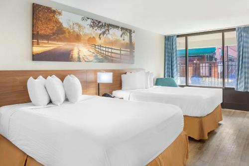落基山黄金东部落基山戴斯酒店的酒店客房设有两张床和窗户。