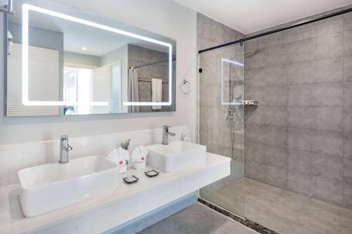 Ramada by Wyndham St Kitts Resort的一间带两个水槽和玻璃淋浴间的浴室