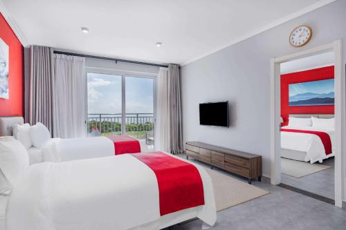 Ramada by Wyndham St Kitts Resort的酒店客房设有两张床和电视。