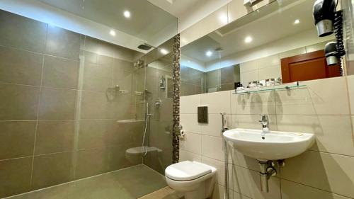 里加Riga Unimars Hotel的浴室配有卫生间、盥洗盆和淋浴。