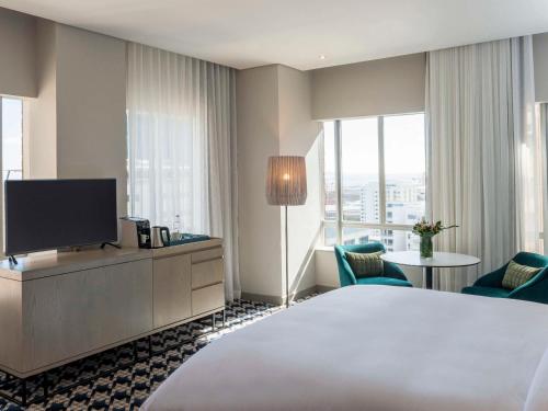开普敦Pullman Cape Town City Centre的配有一张床和一台平面电视的酒店客房