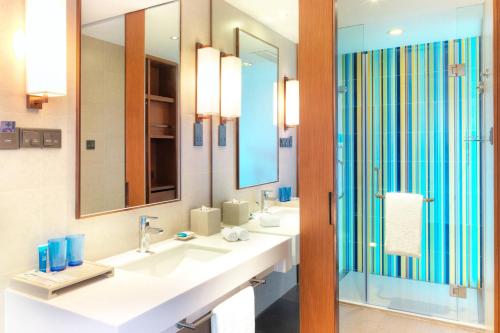 大连大连雅乐轩酒店的浴室设有2个水槽和2面镜子